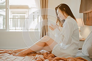 Young woman asia living at home relaxing and drinking cup of hot coffee in the bedroom on holiday.