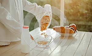 Young woman asia wake up refreshed in the morning and relaxing eat coffee, cornflakes, bread and apple for breakfast at house on h