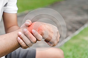 Young woman asian have accident and holding her wrist pain twist sprain in sport exercise jogging, selective focus