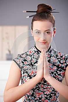 Young woman in asian outfit praying