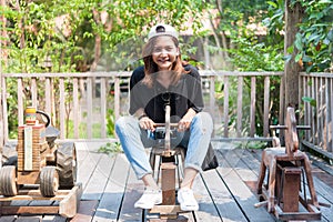 Young woman asian she rides a toy wood horse on the carousel wit