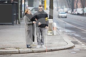 Woman Assisting Blind Man On Street