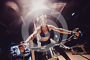 Young woman athlete with an active lifestyle pulls on the training appliance for the arms, chest and back