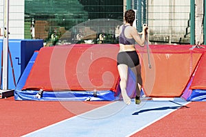 young woman athlete performs the high jump pole vault