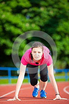 Young woman athlete in starting position