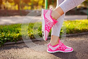 Young woman athlete warming up before running on sportsground in summer. Active lifestyle