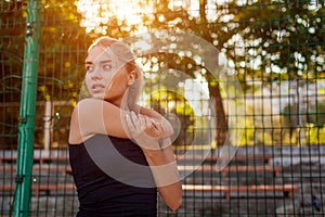 Young woman athlete warming up before running on sportsground in summer. Active lifestyle