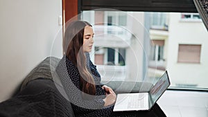 Young woman attending therapy session online, female talking with virtual psychologist at home