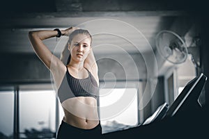 Young woman attractive fitness exercise workout in gym. Woman stretching the muscles and relaxing after exercise