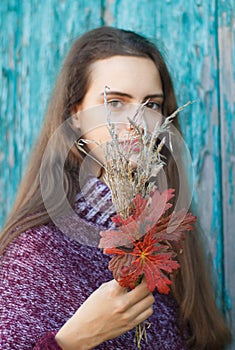 Portrait of a pretty young teenage girl 13-16 years old. Young woman with autumn flowers closeup