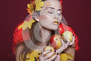 Young woman with autumn make up and leaves on head