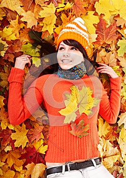 Young woman in autumn orange leaves.