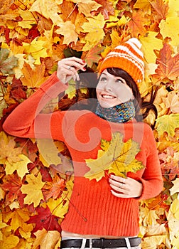 Young woman in autumn orange leaves.