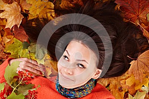 Young woman in autumn orange leaves.