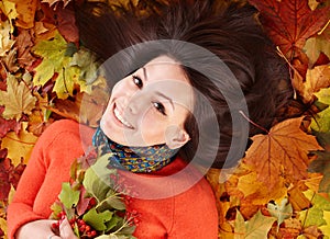 Young woman in autumn orange leaves.