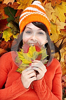 Young woman in autumn orange leaves.