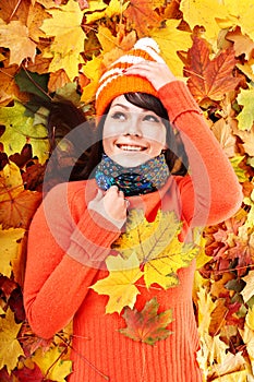 Young woman in autumn orange leaves.