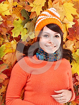 Young woman in autumn orange leaves.