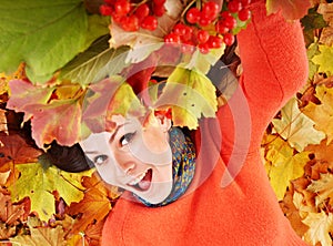 Young woman in autumn orange leaves.