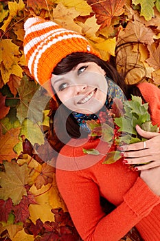 Young woman in autumn orange leaves.
