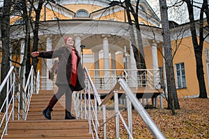 Young woman on the background of a historic building in an autumn park