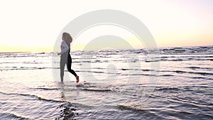 A young woman on the background of the sunset the sun on the seashore does exercises exercised by running, stretching and slumping