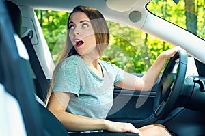 Young woman backing up in a new car