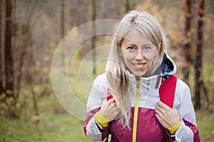 Young woman with backpack hiking in woods photo