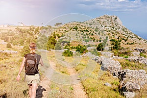 Young woman with backpack at mountain trail.