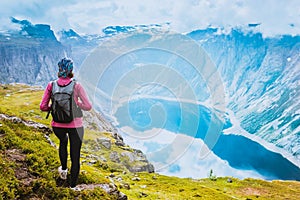 Young woman with backpack on top of fjord Norway