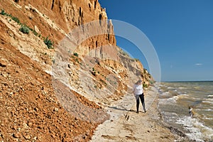 Young woman and backpack walks alone along a sand hill