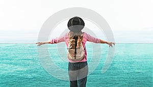 Young woman backpacker exploring new destinations - Back view of travel girl looking the ocean horizon