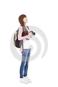 Young woman backpacker holding a camera