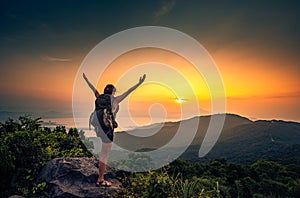 Young hiker standing with arms stretched on top of the Mountain Ban Co Peak, Da Nang Vietnam