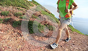 Young woman backpacker walking on seaside mountain photo