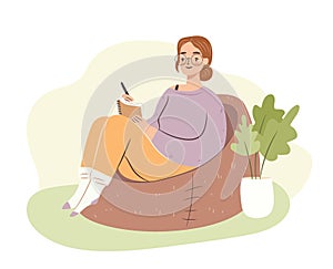 Young woman in bag chair studying. Student girl writing in notebook, journaling. Hygge home atmosphere. Flat vector