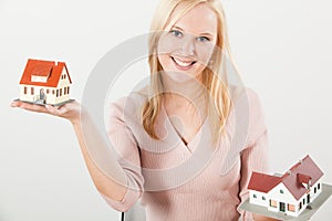 Young woman balancing two houses with hands