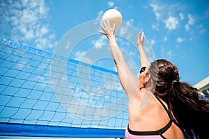 Young woman with ball playing volleyball on beach