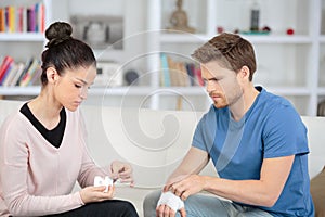 Young woman bandage boyfriend with first aid kit