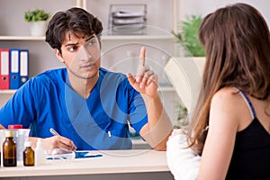 The young woman with bandaged arm visiting male doctor traumotologist