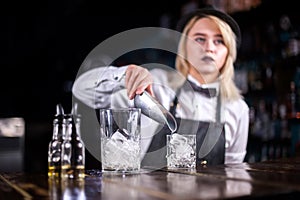 Young woman bartending demonstrates his professional skills in the night club