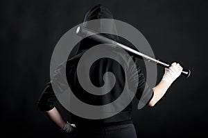 Young woman with a baseball bat. View from the back. hoodlum photo