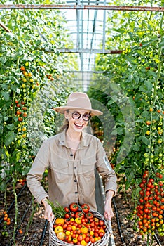 Young woman with basket full of fresh tomatoes