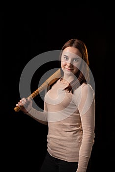 Young woman with a bat on a dark background. Self-defense, psychological protection, mental strength, inner peace concept