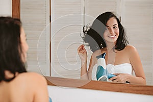 Young woman in bath towel drying hair