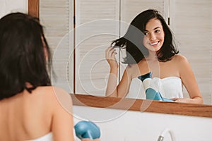 Young woman in bath towel drying hair