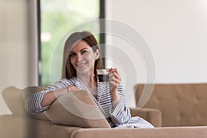 Young woman in a bathrobe enjoying morning coffee