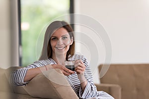 Young woman in a bathrobe enjoying morning coffee