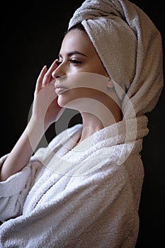 Young woman in a bathrobe and towel on her head, spa and care portrait, clean face