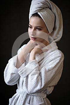 Young woman in a bathrobe and towel on her head, spa and care portrait, clean face